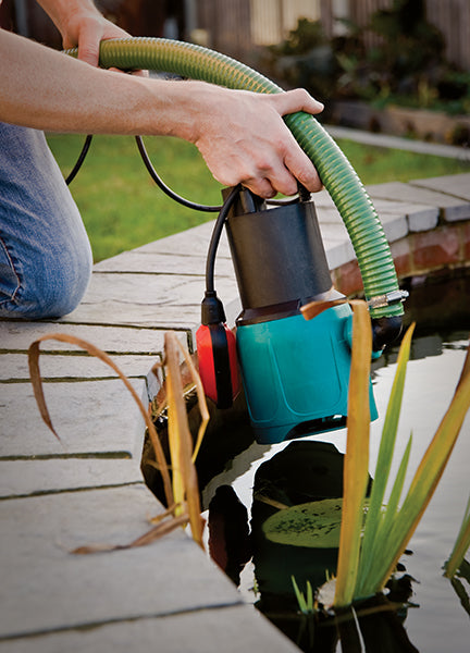 TP Fish Pond and Water Features Pump- location shot of pump being placed into a garden pond