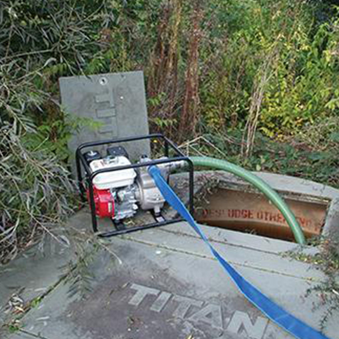 TED Heavy Duty Trash Pump- location shot, pump removing waste from underground with hose attachment