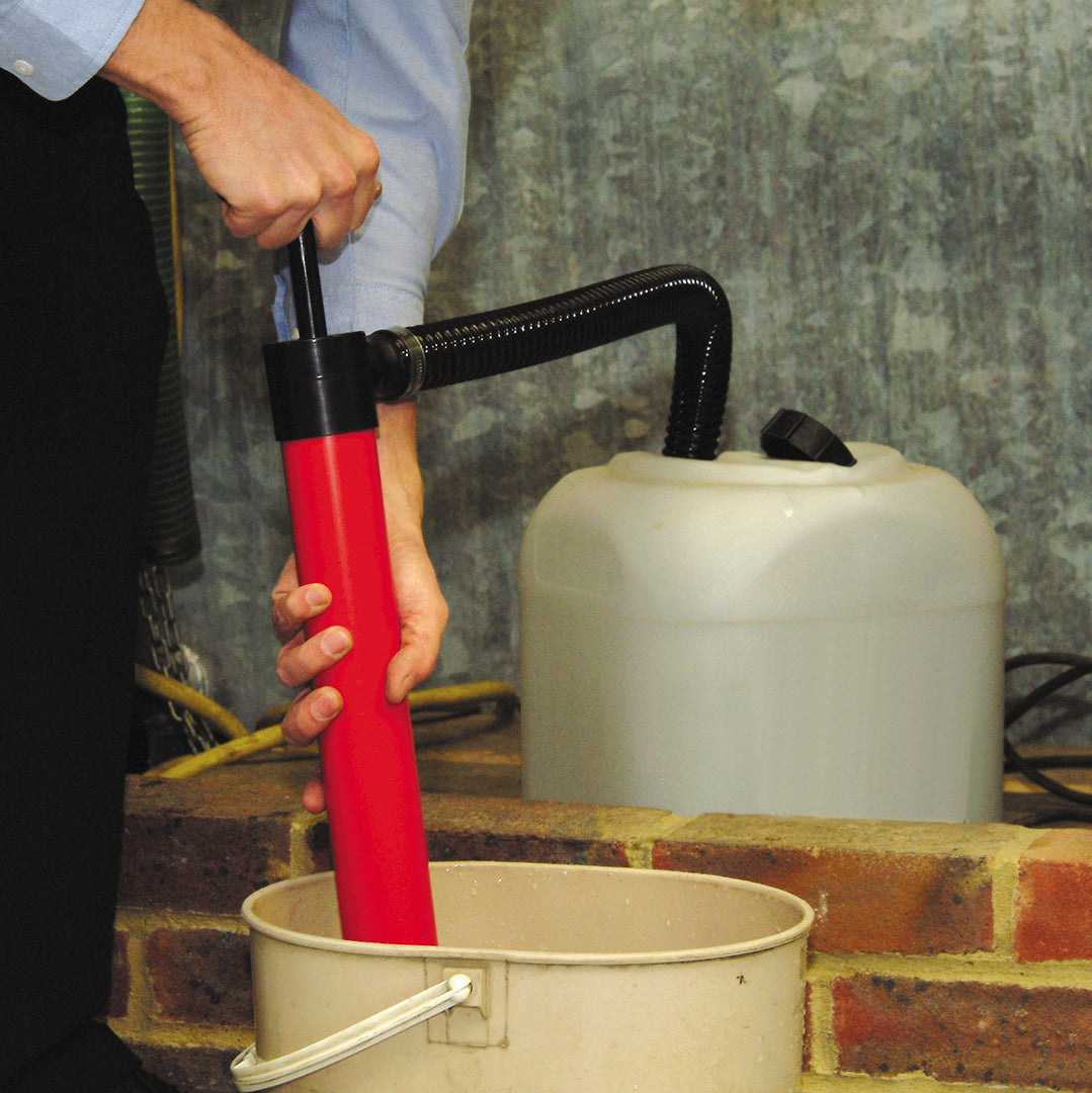 Obart Select Dinghy Bailer (hand pump)- location shot, showing man transferring water from bucket to container 